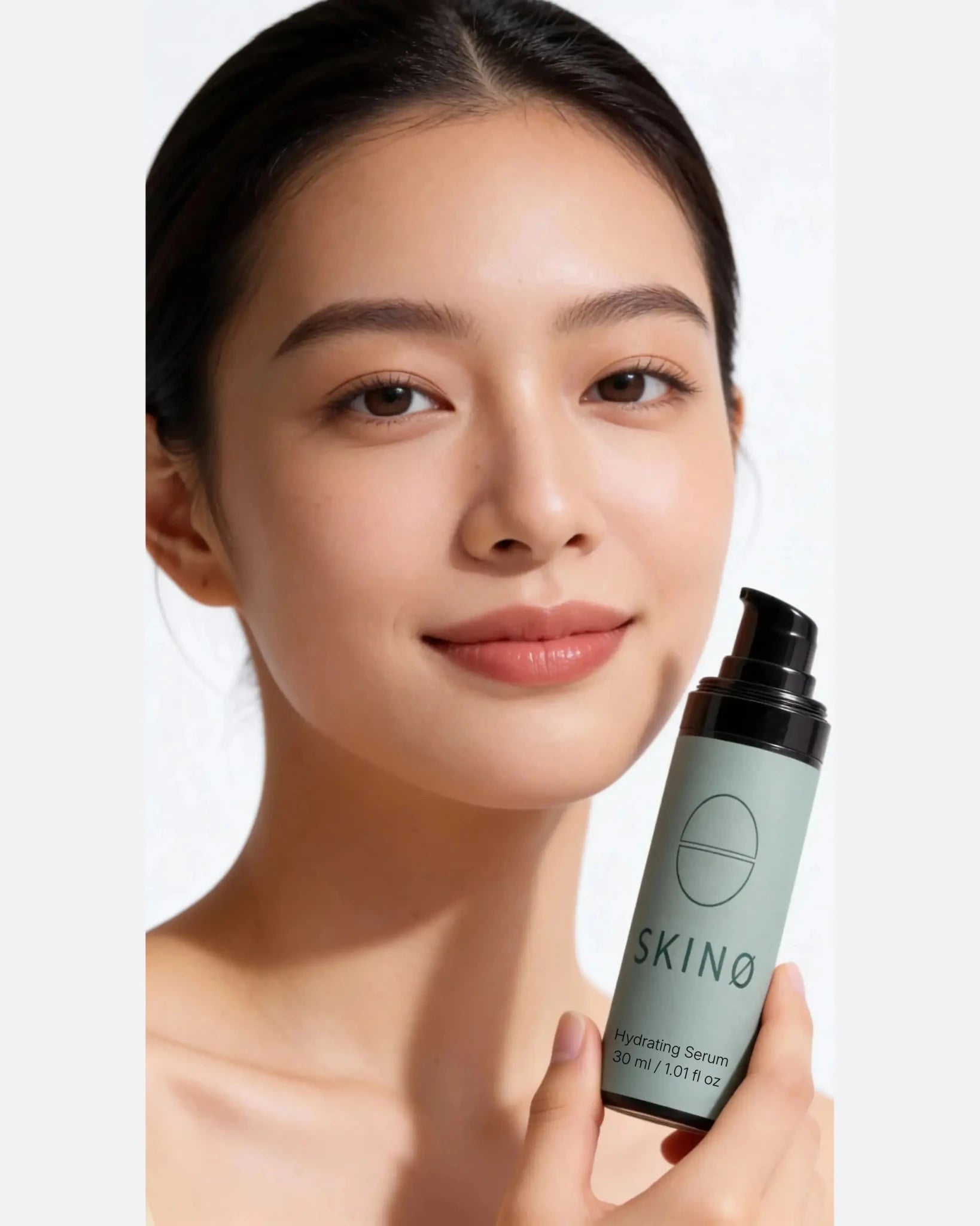 Kvinna med strålande och jämn hud håller SKINØ Hydrating Serum 30 ml – intensivt fuktgivande ansiktsserum med hyaluronsyra och hjortron för mjuk, återfuktad och hälsosam hud, ECOCERT COSMOS ORGANIC.